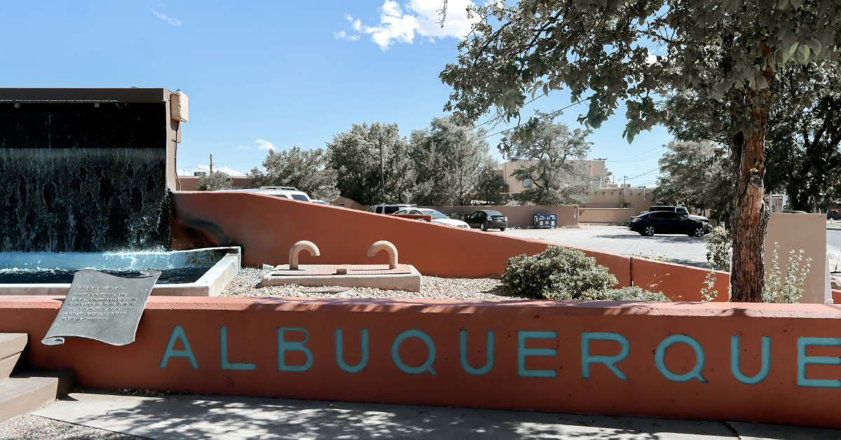 A fountain and a large red sandstone sign that says Albuquerque in large turquoise letters near Kirtland AFB.
